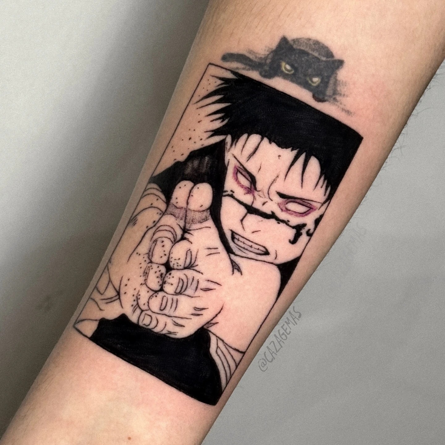 Black manga panel tattoo of a character with a facial scar clenching a fist, with a small black cat on top